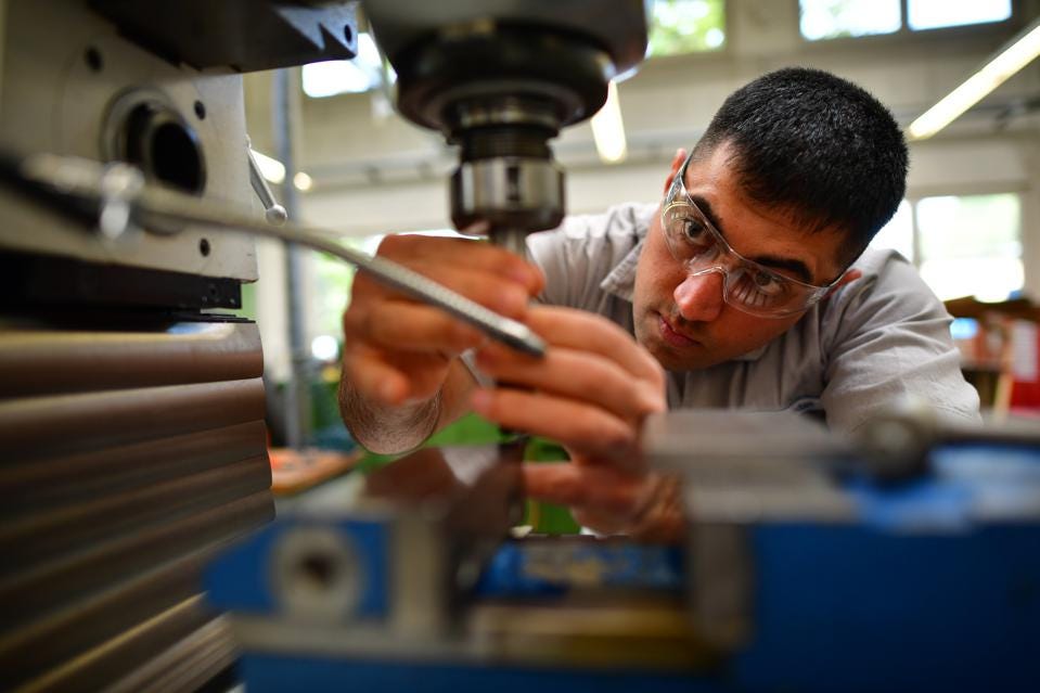 man in safety glasses controlling microscope lens